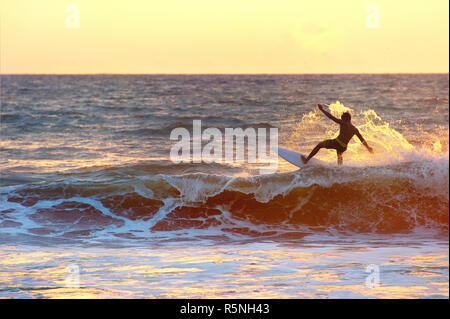 Surfer al tramonto, silhouette Foto Stock