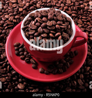 Caffè rosso tazza riempita di fagioli arrosto closeup Foto Stock