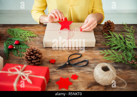 Mani di donna irriconoscibile che avvolgono con nastro un regalo rosa,  scatola regalo, natale o altro regalo fatto a mano di festa, facendo arco  al momento scatola, d Foto stock - Alamy