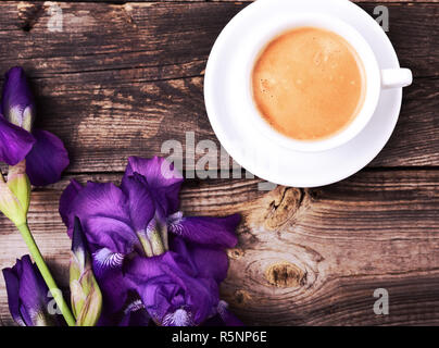 Tazza di caffè nero con un bouquet di iridi blu Foto Stock