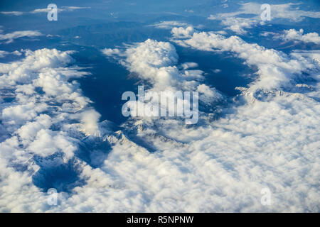 Vista aerea del bianco delle nuvole che coprono le innevate montagne dei Carpazi, Europa; vista aereo Foto Stock