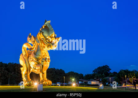 CHIANG RAI, Thailandia-OCT. 27 2016: oro Singha statua a Singha Park è il simbolo di Boon Rawd casale circondato da sotto i riflettori durante il crepuscolo sul cielo azzurro sfondo, famosa destinazione turistica, OCT. 27 2016 in Thailandia Foto Stock