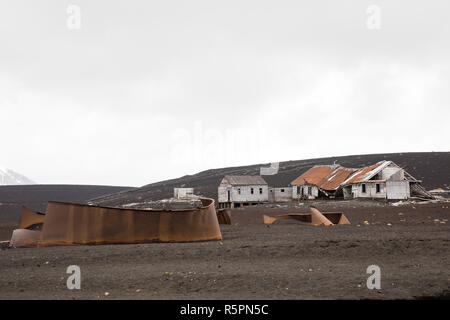 Vecchi serbatoi arrugginiti e edifici fatiscenti per i resti della vecchia stazione baleniera a Whalers Bay, isola Deception, Antartide Foto Stock