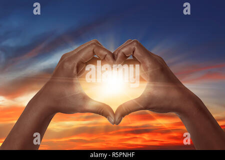 A forma di cuore ad mano con sunrise Foto Stock