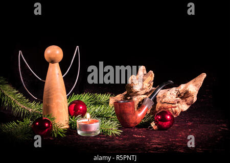 Angelo in legno e tubo decorate con abeti e baubles di natale Foto Stock