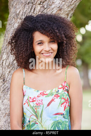 Razza mista donna sorridente felicemente in un parco Foto Stock