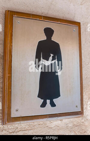 Un segno raffigurante un uomo dell'Oman, indossando una caviglia-lunghezza robe chiamato dishdasha e un pugnale tradizionale noto come khanjar Foto Stock
