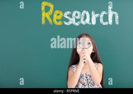 Incredibile ragazza con lente di ingrandimento con il concetto di ricerca Foto Stock