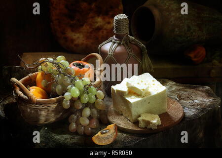 Di vino bianco con vino bianco e frutti su un tavolo di legno Foto Stock