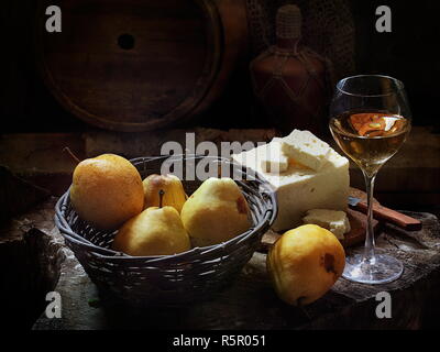 Di vino bianco con vino bianco e frutti su un tavolo di legno Foto Stock