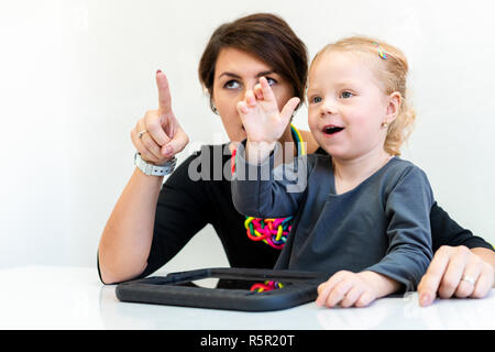 Il Toddler ragazza nel Bambino di terapia occupazionale facendo sessione sensoriale esercizi giocosi con il suo terapeuta. Foto Stock