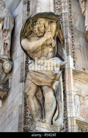 Atlanti scolpiti a sostegno della facciata principale del Duomo di Milano e il Duomo di Santa Maria Nascente, Milano, Lombardia, Italia Foto Stock