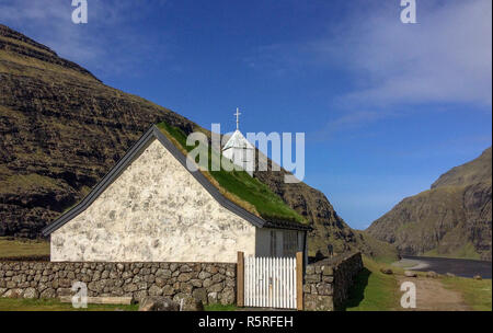 Piccola chiesa di bianco con un tetto di erba a Saksun nel nord delle isole Faerøer Foto Stock