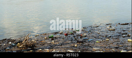 Bottiglie di plastica e di altri rifiuti che inquinano il fiume Foto Stock