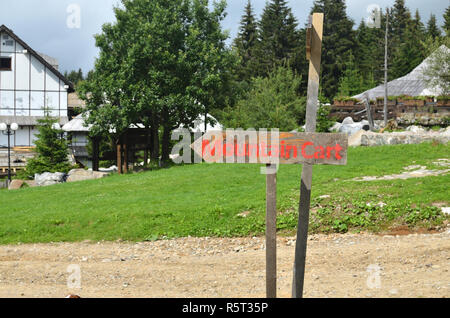 Cartello in legno con un titolo - Mountain carrello - mostra a sinistra, in un paesaggio di campagna Foto Stock