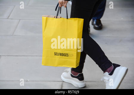 Primo piano di un acquirente che trasporta una borsa di carta Selfridges Department Store a Oxford Street, Londra, Inghilterra, Regno Unito Foto Stock