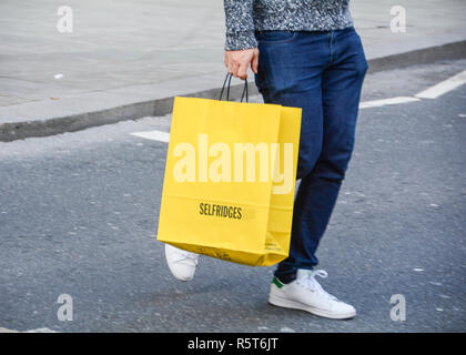 Gli amanti dello shopping che porta dal grande magazzino Selfridges supporto di carta sacchetti, Oxford Street, London, Regno Unito Foto Stock