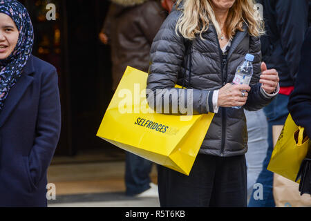 Gli amanti dello shopping che porta dal grande magazzino Selfridges supporto di carta sacchetti, Oxford Street, London, Regno Unito Foto Stock