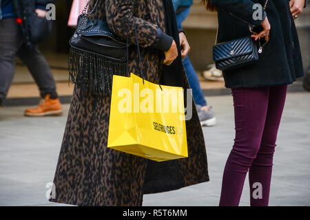 Gli amanti dello shopping che porta dal grande magazzino Selfridges supporto di carta sacchetti, Oxford Street, London, Regno Unito Foto Stock