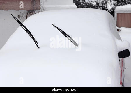 In inverno il traffico. Un nevicato auto rossa Foto Stock