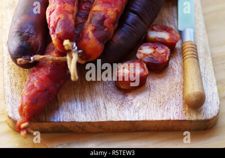 Salsiccia portoghese chourico e il coltello sul tavolo Foto Stock