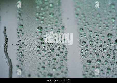 Primo piano delle gocce di pioggia sulla vettura di vetro con rivestimento idrofobo Foto Stock