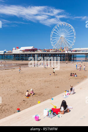 Blackpool beach summer ferris wheel on Blackpool central pier Blackpool with people on the sandy beach at Blackpool Lancashire England UK GB Europe Foto Stock