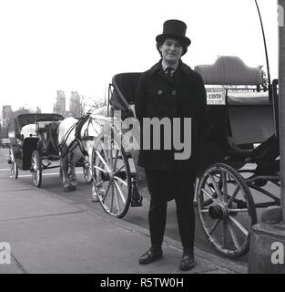 Anni sessanta, storico, una lady driver nel suo vestito e hat in attesa per i passeggeri a fianco del suo open-air carrozza e cavalli per visite turistiche passeggiate intorno al central Park di New York, Stati Uniti d'America. Foto Stock