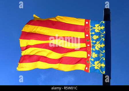 Bandiera di Valencia, Spagna, agitando al vento nella parte anteriore di un cielo blu, isolato e soleggiato. Foto Stock