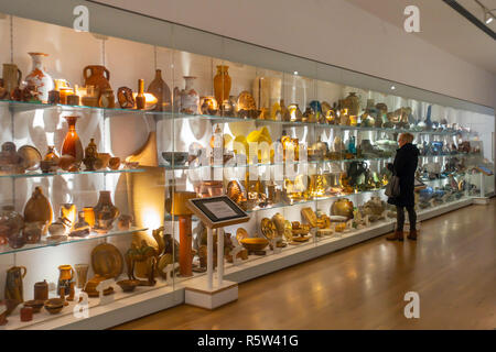 Una donna ammirando una parte della vasta collezione permanente di arte ceramica al premiato York Art Gallery Foto Stock