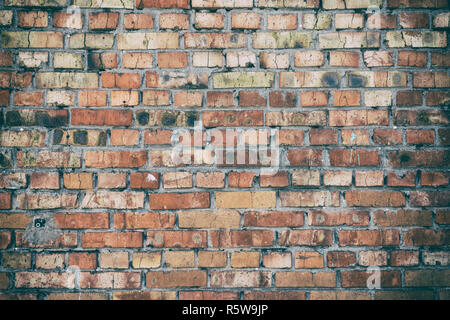 Muro di mattoni rossi con uno strato di cemento grigio Foto Stock