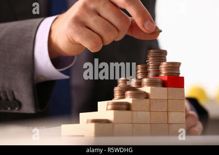 Imprenditore a mano mettendo i soldi pin Foto Stock