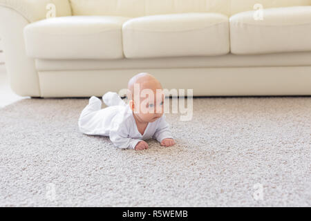 Famiglia, concetto di infanzia - Close up ritratto di pretty baby giacciono sul pavimento Foto Stock