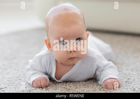 Famiglia, concetto di infanzia - Close up ritratto di pretty baby giacciono sul pavimento Foto Stock