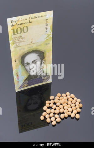 Iperinflazione concetto - venezuelano (Bolivar Fuerte tipo) con alimento (soia) - metafora di gonfiaggio di spiralatura in Venezuela & sprecato denaro. Foto Stock