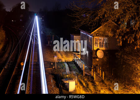 La luce bianca sentieri di notte dal passaggio di un treno a Gilberdyke passando il segnale meccanico scatola, appena una settimana prima della chiusura Foto Stock