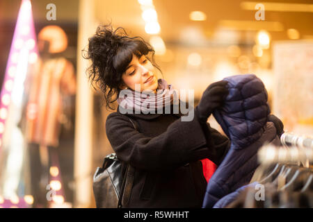 Donna sorridente vestiti shopping, Germania Foto Stock