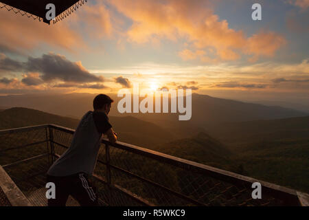 Ragazzo che guarda alla lontana Smoky mountains al tramonto in Asheville, Carolina del Nord Foto Stock