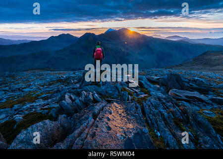 La figura nelle montagne di Snowdonia, con snowdon in background Foto Stock