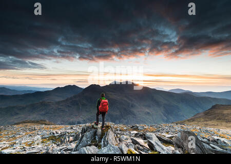 La figura nelle montagne di Snowdonia, con snowdon in background Foto Stock