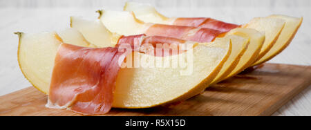 Fette di melone avvolti nel prosciutto, vista laterale. Close-up. Foto Stock