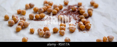 Ceci arrosto con spezie sulla carta da forno, primo piano. Foto Stock