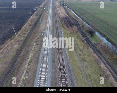 Tracciato ferroviario. Vista superiore sulle rotaie. Le linee elettriche ad alta tensione per i treni elettrici Foto Stock