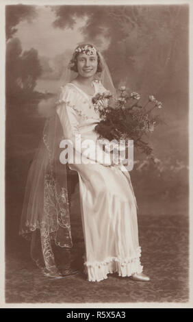 * Vintage Plymouth vera Cartolina fotografica di una donna nel suo abito da sposa tenendo un mazzo di fiori. Foto Stock