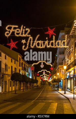 RONDA, Spagna - 12 dicembre 2017: Natale (Feliz Navidad) iscrizione e le decorazioni di Natale sulla Calle Virgen de la Paz street nel centro Foto Stock