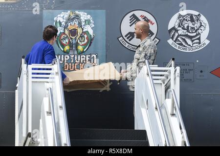 Becky Thatcher, figlia del compianto Doolittle Raider Staff Sgt. David Thatcher, E DEGLI STATI UNITI Air Force Tech. Sgt. William Hatten dal 28 squadrone di manutenzione da Ellsworth Air Force Base, S.D., rotto Duck dedicato capo equipaggio, svelano la più recente riedizione di rotte illustrazioni di anatra durante una cerimonia per la nuova rotta Duck artwork, apr. 17, 2017 a Wright-Patterson Air Force Base in Ohio. L'opera d'arte originale presentava un cross-eyed duck, indossa un casco di cuoio, fissando su attraversato stampelle. Foto Stock