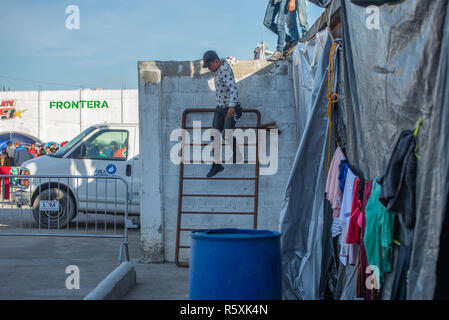 Tijuana, Messico. 2 dicembre 2018 - Aslyum cercatore dal '"migranti caravan'' utilizza una scala di fortuna a El Barretal, il nuovo rifugio in Tijuana, Messico il 2 dicembre 2018. El Barretal, di una sala da ballo e spazi per eventi e si trova a pochi chilometri dal confine, è stata designata come luogo di rifugio per gli americani centrale. Il numero dei migranti è oltre mille e salita al camp. Credito: Vito Di Stefano/ZUMA filo/Alamy Live News Foto Stock