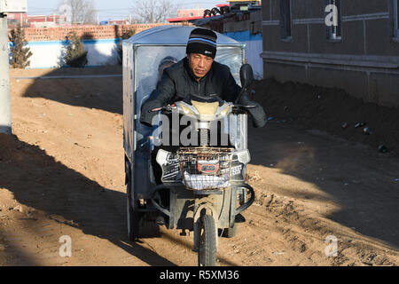 (181203) -- HOHHOT, Dicembre 3, 2018 (Xinhua) -- Liu Hai porta la sua figlia a casa dopo scuola nella città Kouhezi, Kulun Banner del nord della Cina di Mongolia Interna Regione Autonoma, nov. 29, 2018. Liu Hai, un soldato in pensione che ha perso le sue braccia in un incidente di lavoro nel 1997, e li Meiwen, che ha perso le sue gambe quando aveva tredici anni, sono state nel matrimonio per undici anni attraverso l aiuto reciproco nella vita. Dopo conoscere Li Meiwen sulla TV in 2007, Liu hai messo in contatto con lei. Due mesi più tardi, Li è andato alla Mongolia interna per la prima volta. Sebbene ricevere aiuto da parte di parenti e amici, il giovane ancora provare a Foto Stock