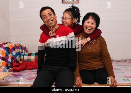 (181203) -- HOHHOT, Dicembre 3, 2018 (Xinhua) -- La famiglia di Liu Hai posano per una foto a casa nella città Kouhezi, Kulun Banner del nord della Cina di Mongolia Interna Regione Autonoma, nov. 30, 2018. Liu Hai, un soldato in pensione che ha perso le sue braccia in un incidente di lavoro nel 1997, e li Meiwen, che ha perso le sue gambe quando aveva tredici anni, sono state nel matrimonio per undici anni attraverso l aiuto reciproco nella vita. Dopo conoscere Li Meiwen sulla TV in 2007, Liu hai messo in contatto con lei. Due mesi più tardi, Li è andato alla Mongolia interna per la prima volta. Sebbene ricevere aiuto da parte di parenti e amici, il giovane ancora provare a Foto Stock