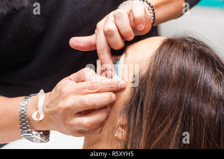 Make up Artist usando del nastro adesivo protettivo per la creazione di occhi di gatto Foto Stock